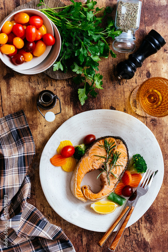 Photography grilled salmon steak with vegetables on a wooden table
