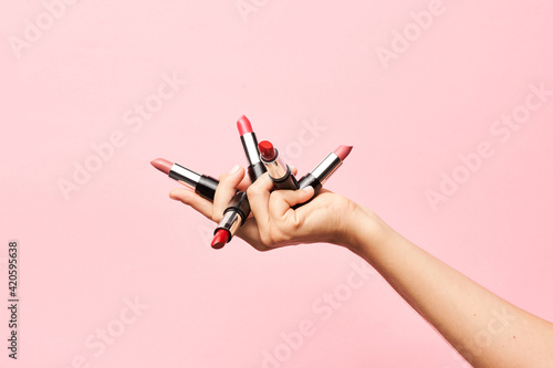 Crop person showing lipsticks for makeup