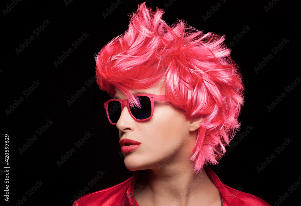 Beauty fashion model girl with stylish red pink hair wearing modern sunglasses. Profile closeup portrait isolated on black