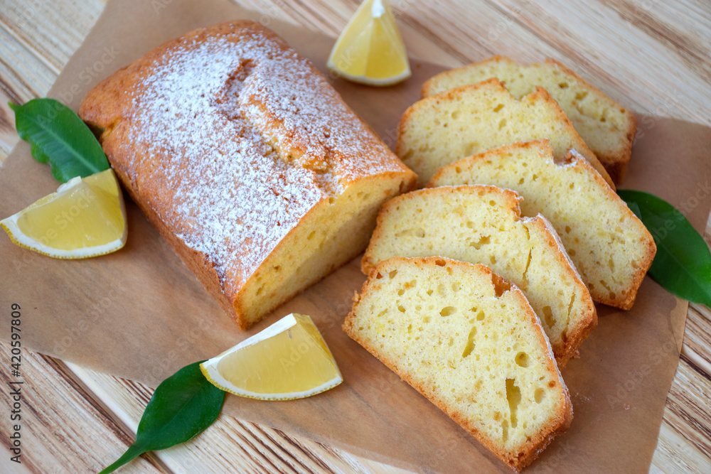 Pieces of lemon cake with full pie, lemons on rustic wooden board. Easy recipe of citrus dessert for everyday cooking. Pieces of lemon cake with full pie, lemons on rustic wooden board. Easy recipe of citrus dessert for everyday cooking.