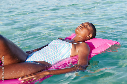 Woman relaxing on a float in the ocean