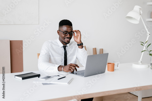 Ethnic manager using laptop at desk photo