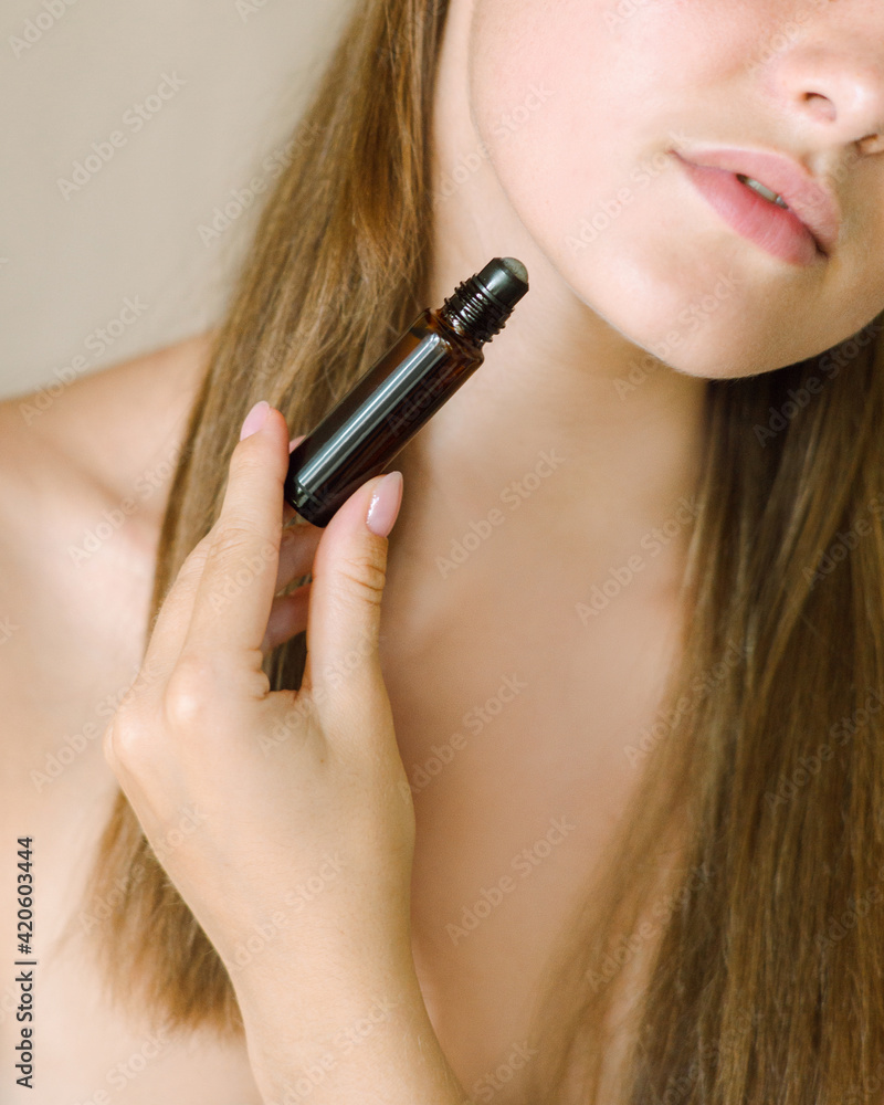 Beautiful girl uses oil roller for her face Beautiful girl uses oil roller for her face