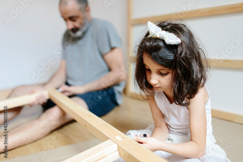 Father and kid assembling furniture