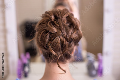 Female back with romantic wedding hairstyle in hairdressing salon