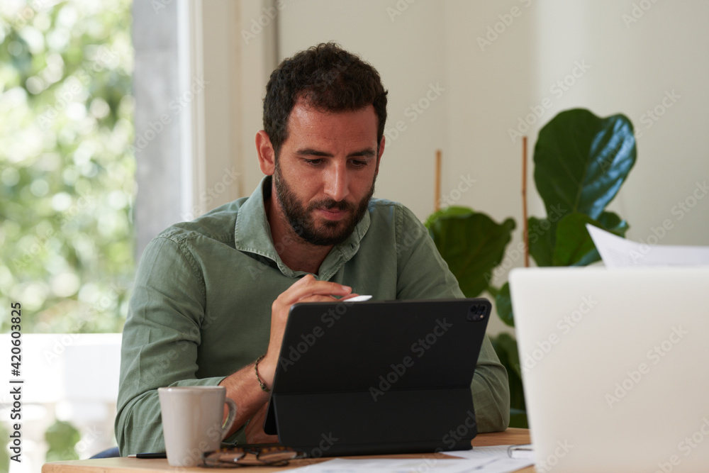 A handsome businessman working on pad. A handsome businessman working on pad.