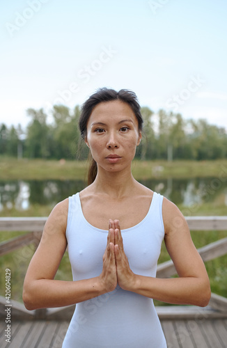 asian woman does street yoga in a Park by the river in summer photo