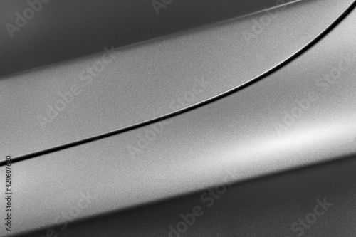 Surface of gray sport sedan, car bodywork, detail of metal fender and hood of modern vehicle, automobile industry, selective focus 