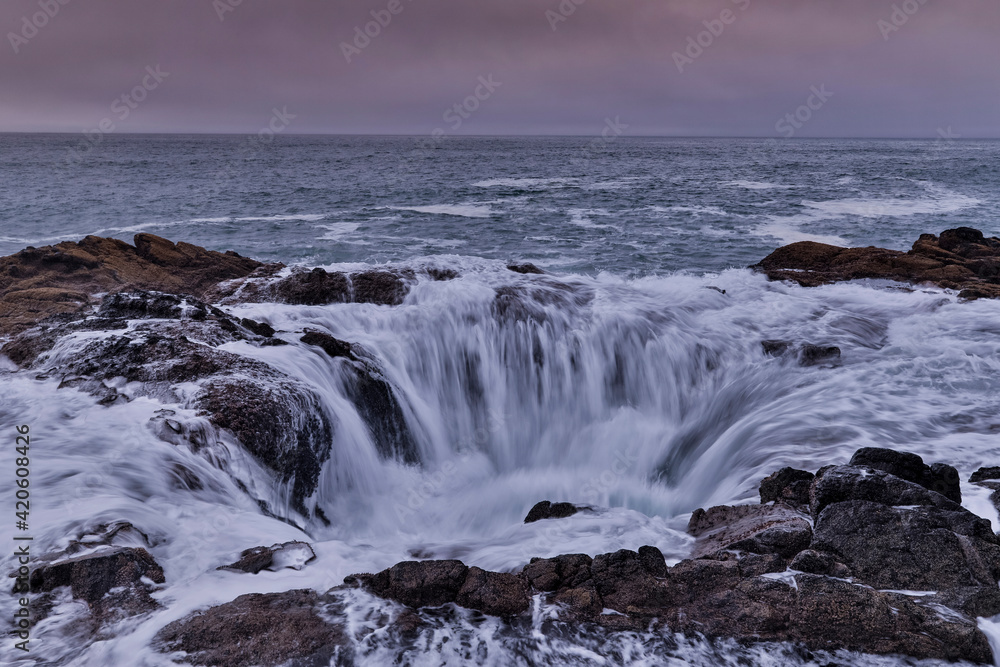 Thor's Well with surf cascading into the well along the Oregon coastline Thor's Well with surf cascading into the well along the Oregon coastline