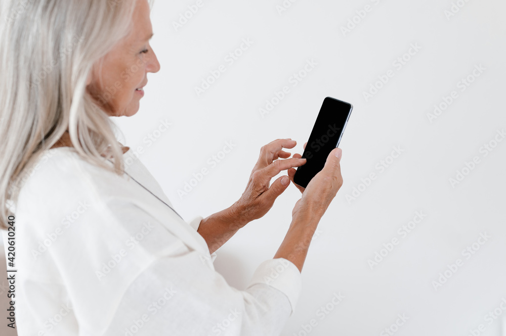 Happy gray haired woman browsing smartphone Happy gray haired woman browsing smartphone