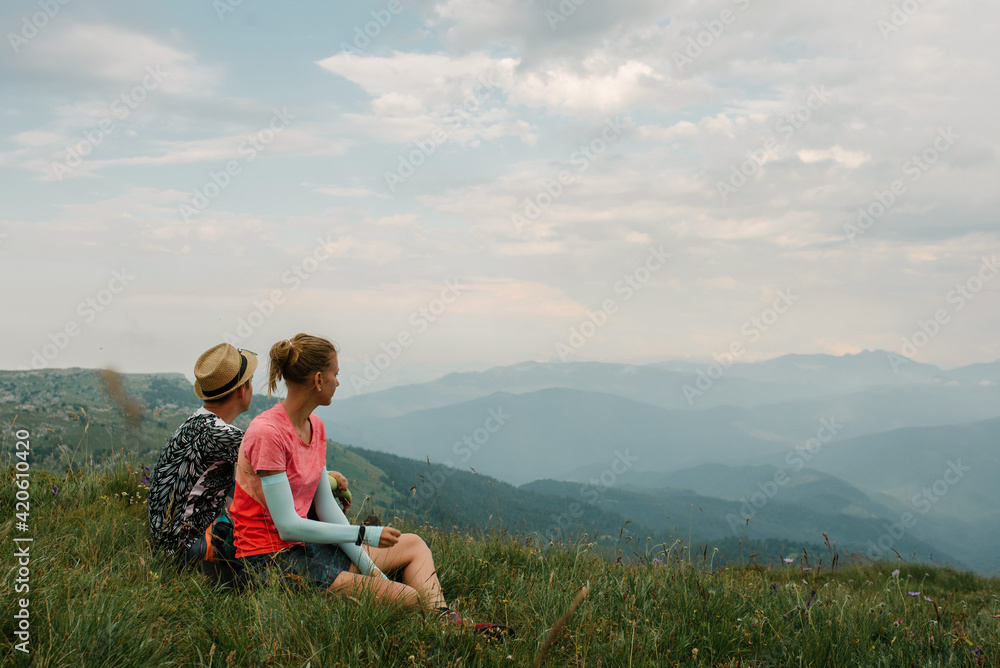 Wonderful view from the mountain peak and a tourist couple on it Wonderful view from the mountain peak and a tourist couple on it