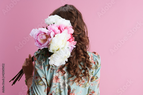 trendy woman with long wavy brunette hair on pink