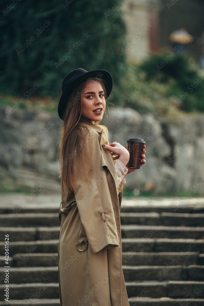 Girl in a coat drinking coffee