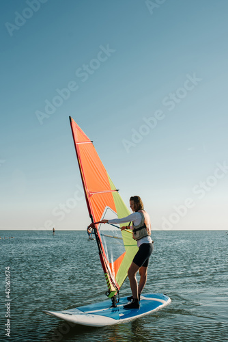 A girl sails on a windsurf on the sea
