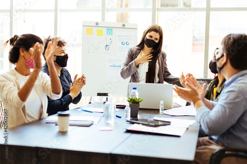 Business team wearing protective masks while meeting in the office during the COVID-19 epidemic © kleberpicui