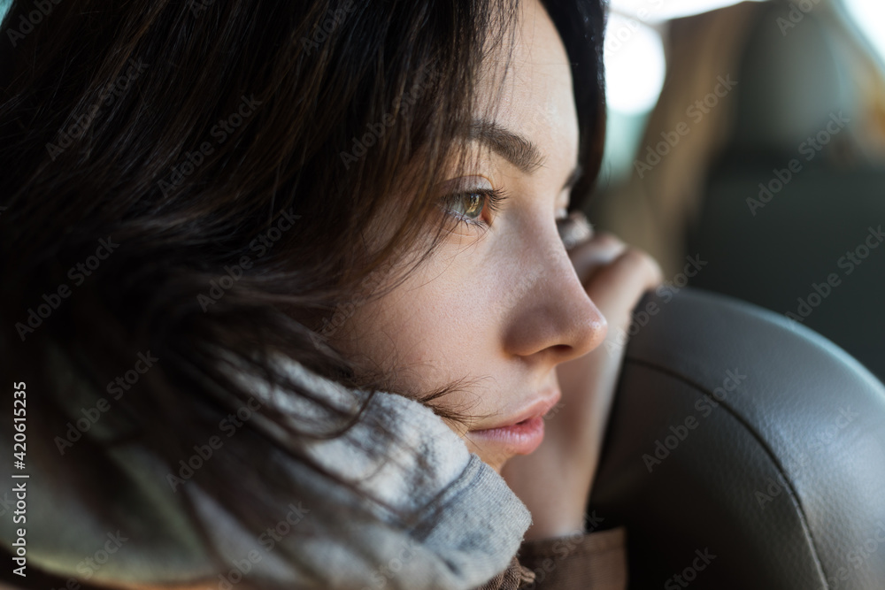 © Demetr White/Stocksy - portrait of a girl who put her face on the back of a car seat © Demetr White/Stocksy - portrait of a girl who put her face on the back of a car seat