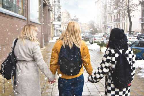 Three student girls walking in the school yard view from back . friendship concept