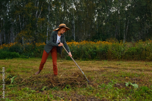 Female farmer cleaning field from grass