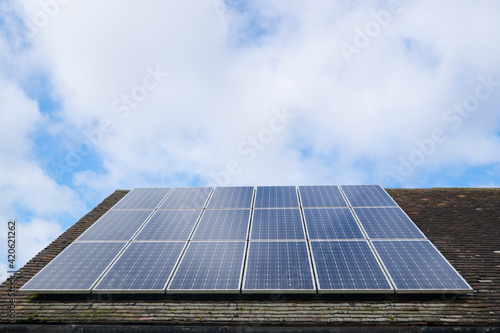 Solar photovoltaic panels on a clay tile roof in England, United Kingdom, with copy space