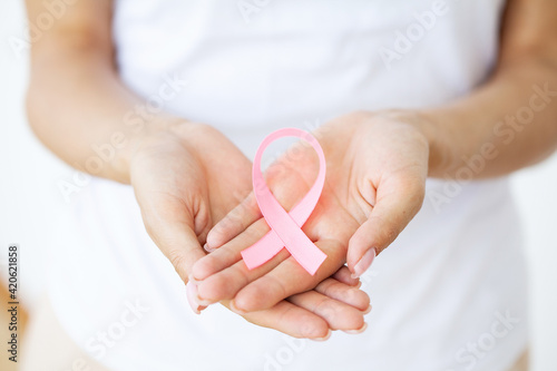 Close up of woman showing pink ribbon symbolizing breast cancer