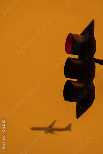 Plane flying over traffic light during sunset