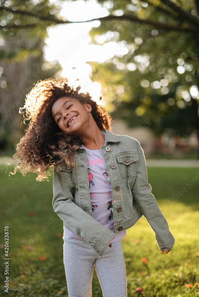 A beautiful, young african american child playing around her front yard and having fun A beautiful, young african american child playing around her front yard and having fun