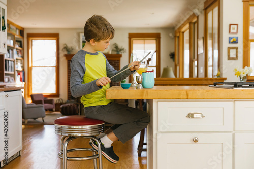 Young Child Alone Playing Drums on Glassware at Home