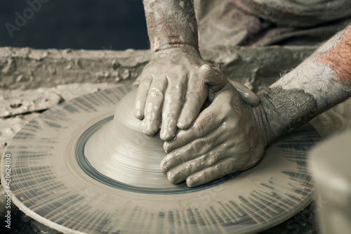 Ceramist, man's hands working on clay photo