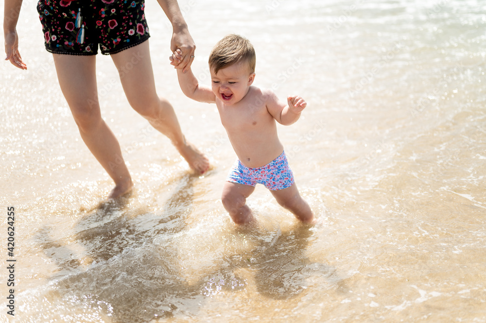 Mother and baby walking on shore Mother and baby walking on shore