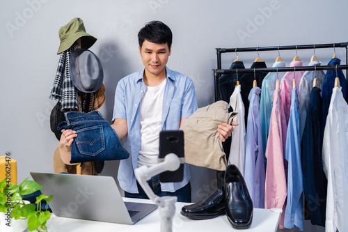 man selling clothes and accessories online by smartphone live streaming, business online e-commerce at home.
