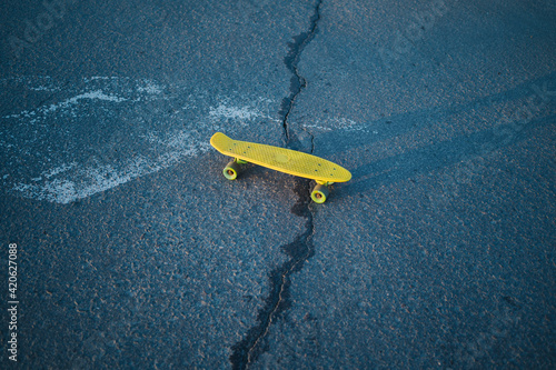 Yellow skateboard and crack in the asphalt photo