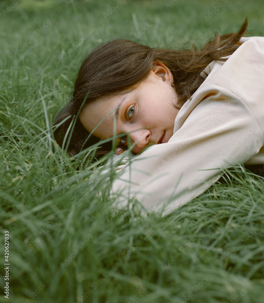 Thoughtful woman lying on grass Thoughtful woman lying on grass