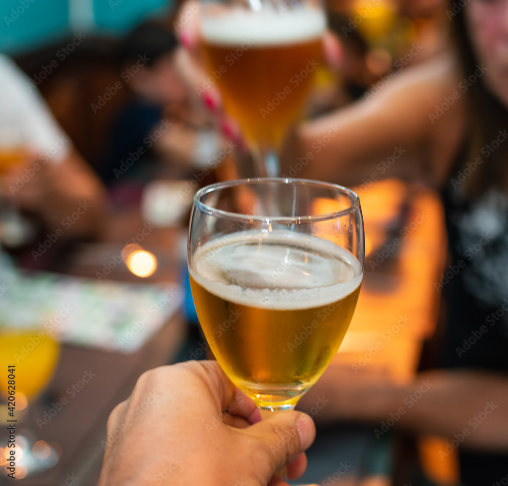 hands holding glasses to toast at a celebration