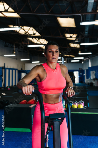 Muscular sportswoman using exercise machine
