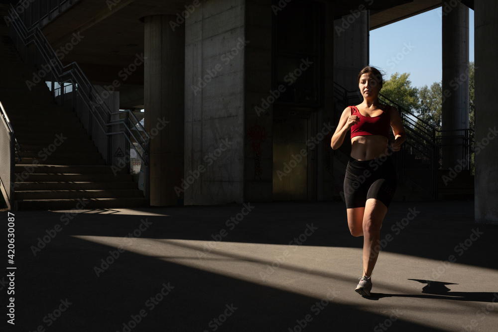 Woman running on the street, under a bridge Woman running on the street, under a bridge