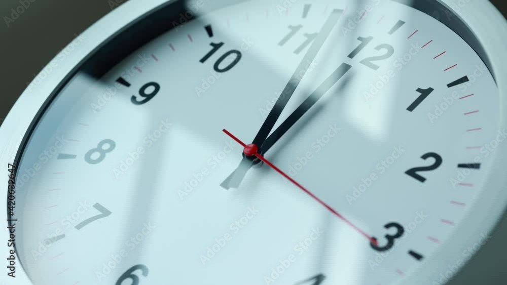 Time lapse movie. Large white wall clock Set the time for 12.00 o'clock. The red minute hand keeps running. Time lapse movie. Large white wall clock Set the time for 12.00 o'clock. The red minute hand keeps running.