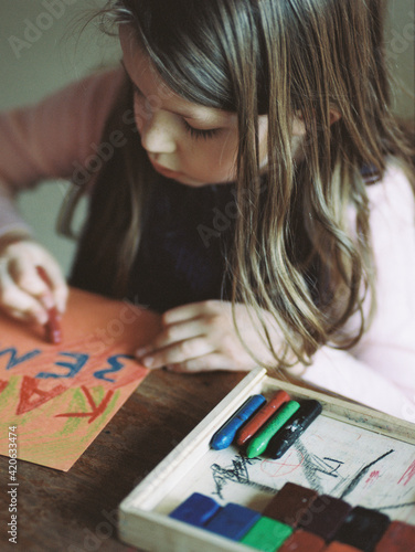 a seven year old draws on paper photo