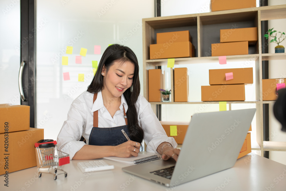 Startup small business SME, Entrepreneur owner working at home office and checking online purchase shopping order to preparing pack product box. Selling online ,Online Shopping ideas concept Startup small business SME, Entrepreneur owner working at home office and checking online purchase shopping order to preparing pack product box. Selling online ,Online Shopping ideas concept