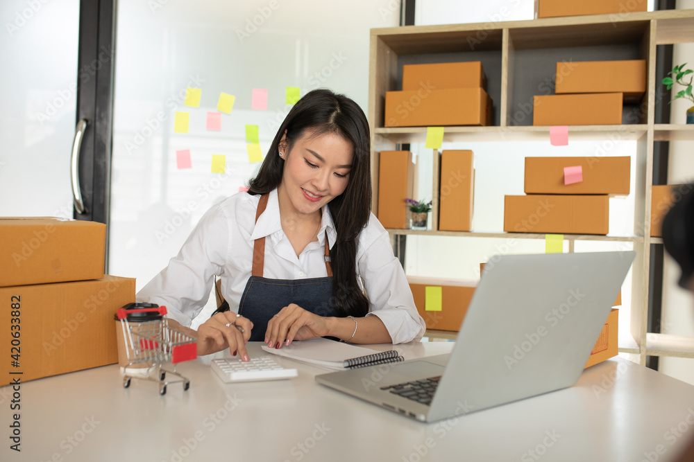 Startup small business SME, Entrepreneur owner working at home office and checking online purchase shopping order to preparing pack product box. Selling online ,Online Shopping ideas concept Startup small business SME, Entrepreneur owner working at home office and checking online purchase shopping order to preparing pack product box. Selling online ,Online Shopping ideas concept