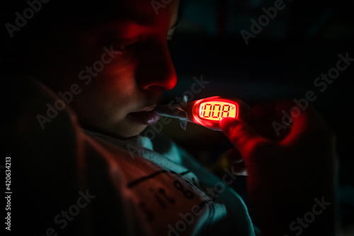 Young child has fever shown on thermometer photo