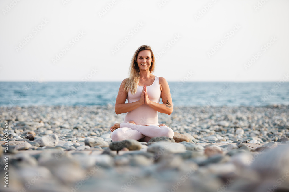 Happy woman meditating near sea Happy woman meditating near sea