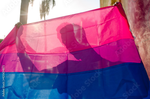Man's silhouette behind Pride banner photo
