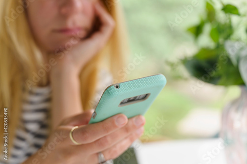 Upset Woman Looking at Smartphone photo