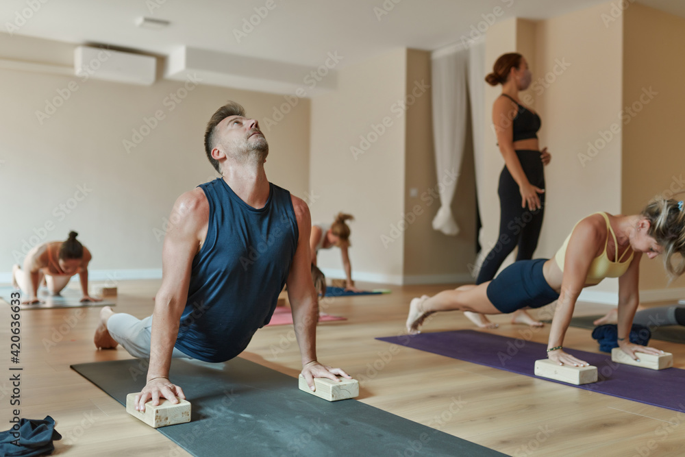 Yoga teacher in class with her students Yoga teacher in class with her students