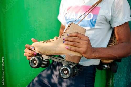 Young black male wearing VALID t-shirt holding rollerskate