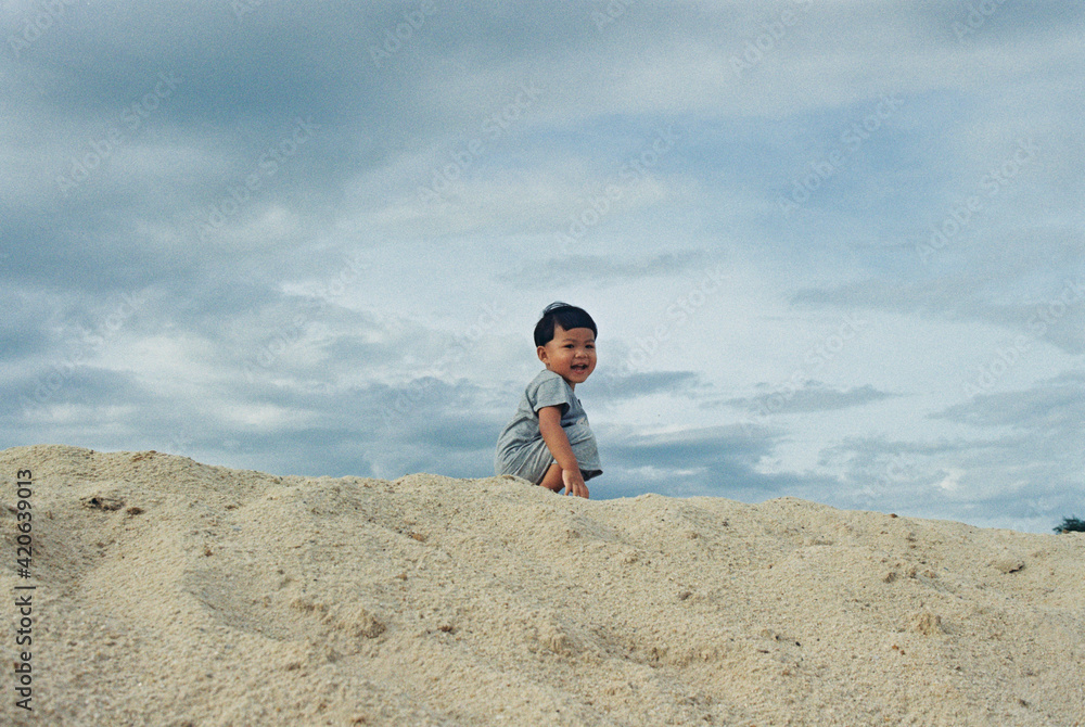 Asian kid playing on the sand Asian kid playing on the sand