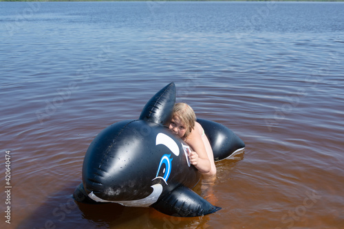 The girl frolics in the water on a hot sunny summer day and is happy. Kuvshinovo, Tver region, Russia. photo