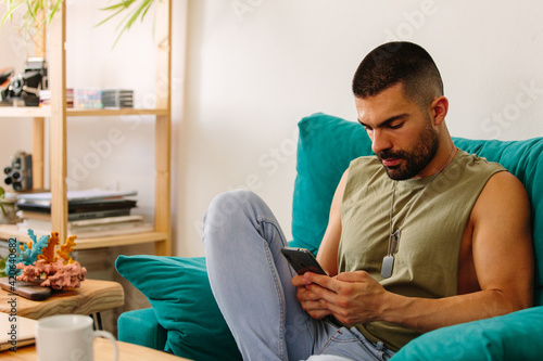 Serious young man with mobile phone photo