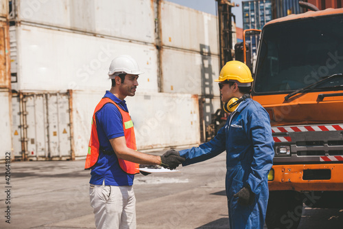 worker staff shaking hand for sucess working at Container. workers prepare export products. Container Shipping Logistics Engineering of Import Export Transportation Industry