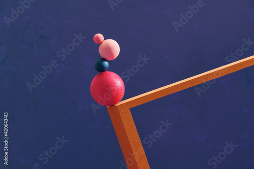 Four color spheres balance on wooden frame